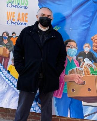 The Rev. Edgar Gutierrez-Duarte pictured next to his "Chelsea Resilient" mural image