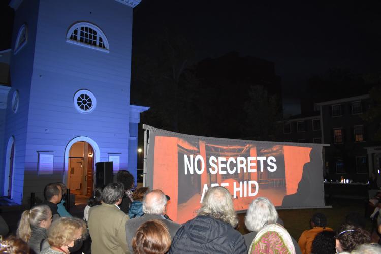 Multitud reunida en el césped de Christ Church Cambridge para el estreno de la película "Here Lies Darby Vassall"